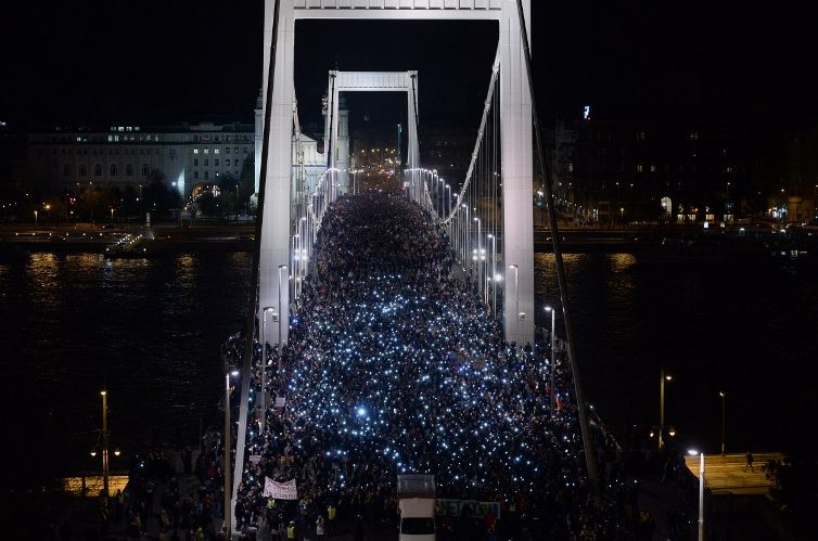 Ten-thousand participants march accross the Elisabeth bridge during an anti-government rally against the goverment's new tax plan for the introduction of the internet tax next year in Budapest on October 28, 2014. AFP PHOTO / ATTILA KISBENEDEK